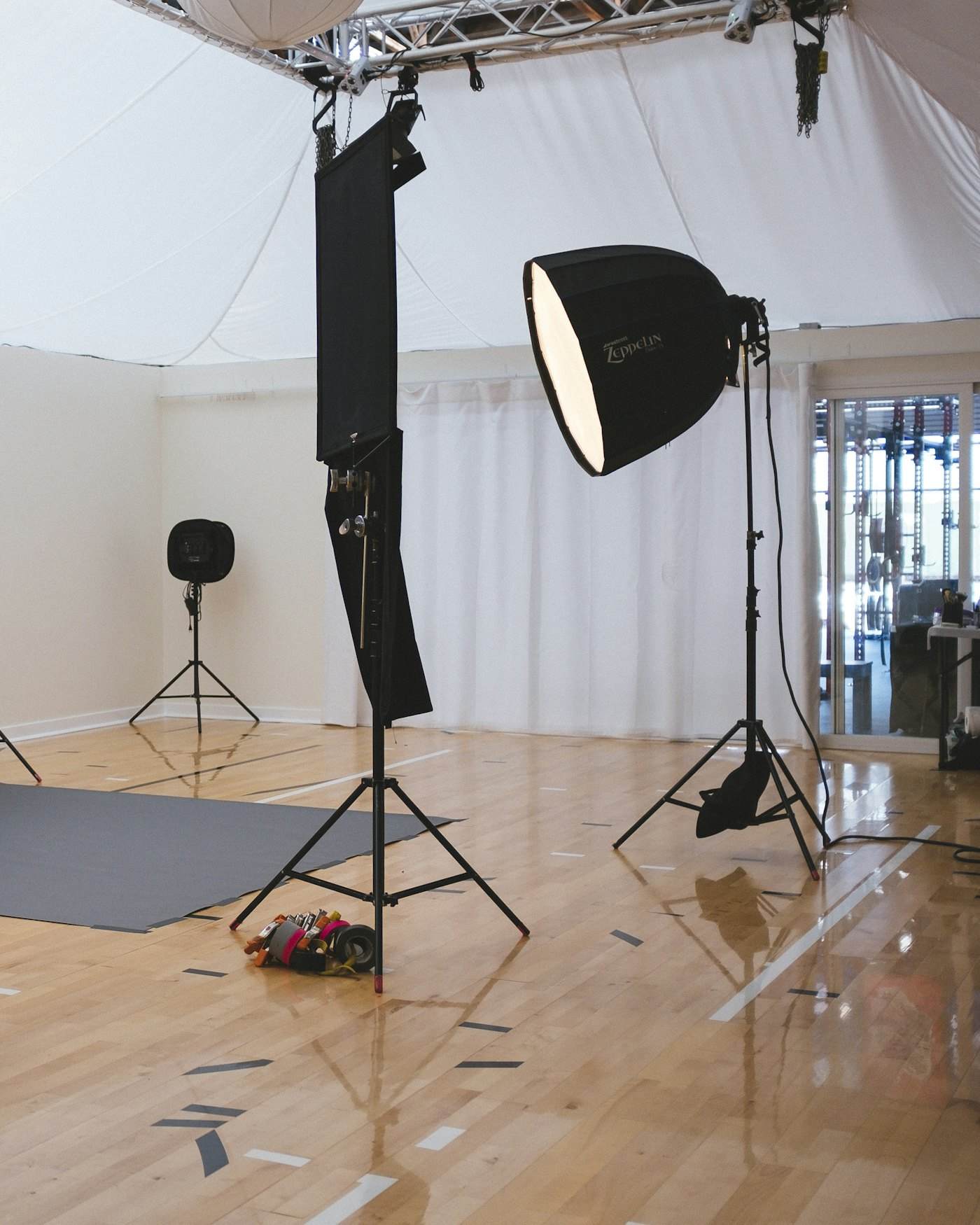 A film studio lit for a night shoot, lamps and stands in silhouette