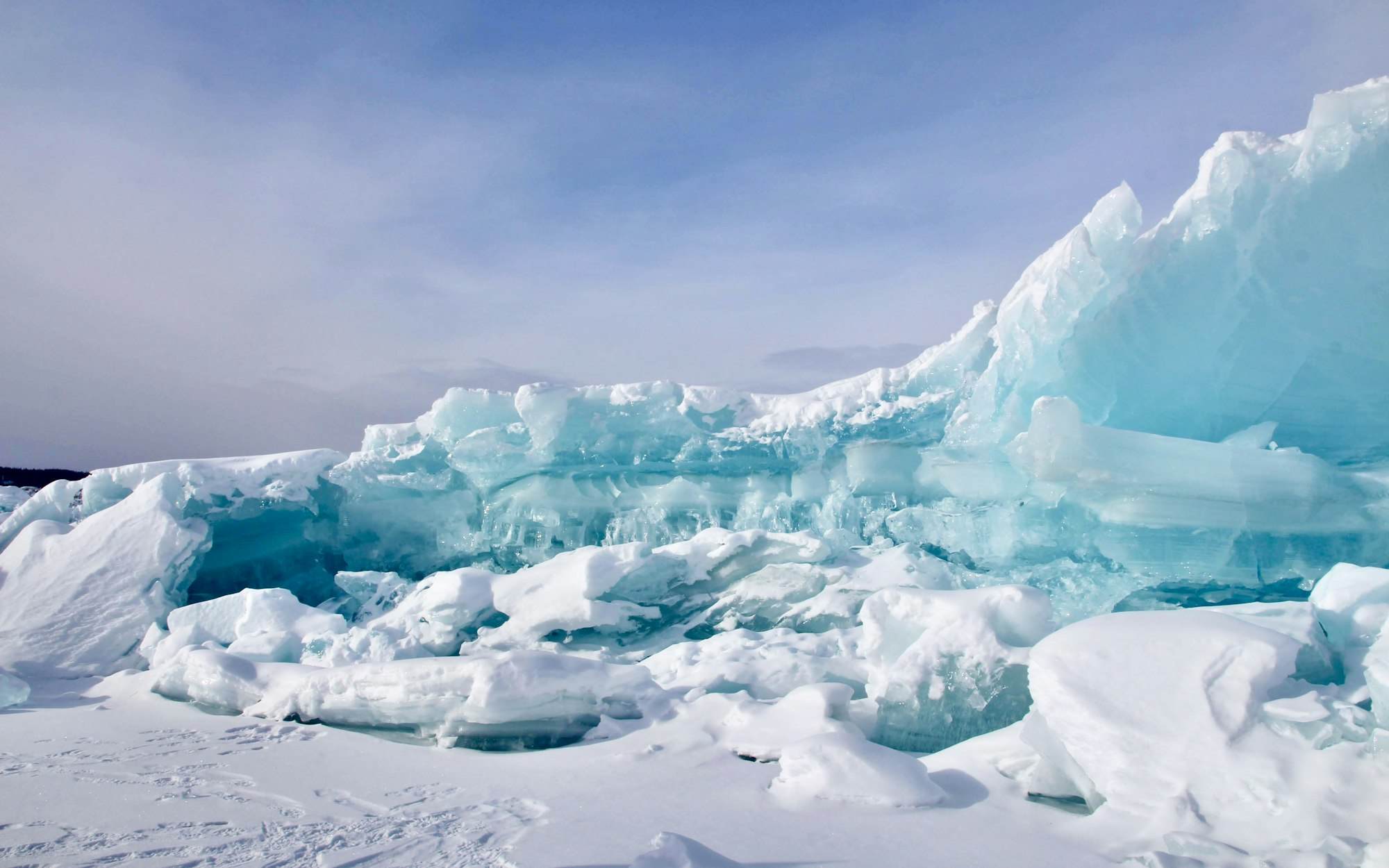 A glacier face lit from behind, ice glowing blue at the edges