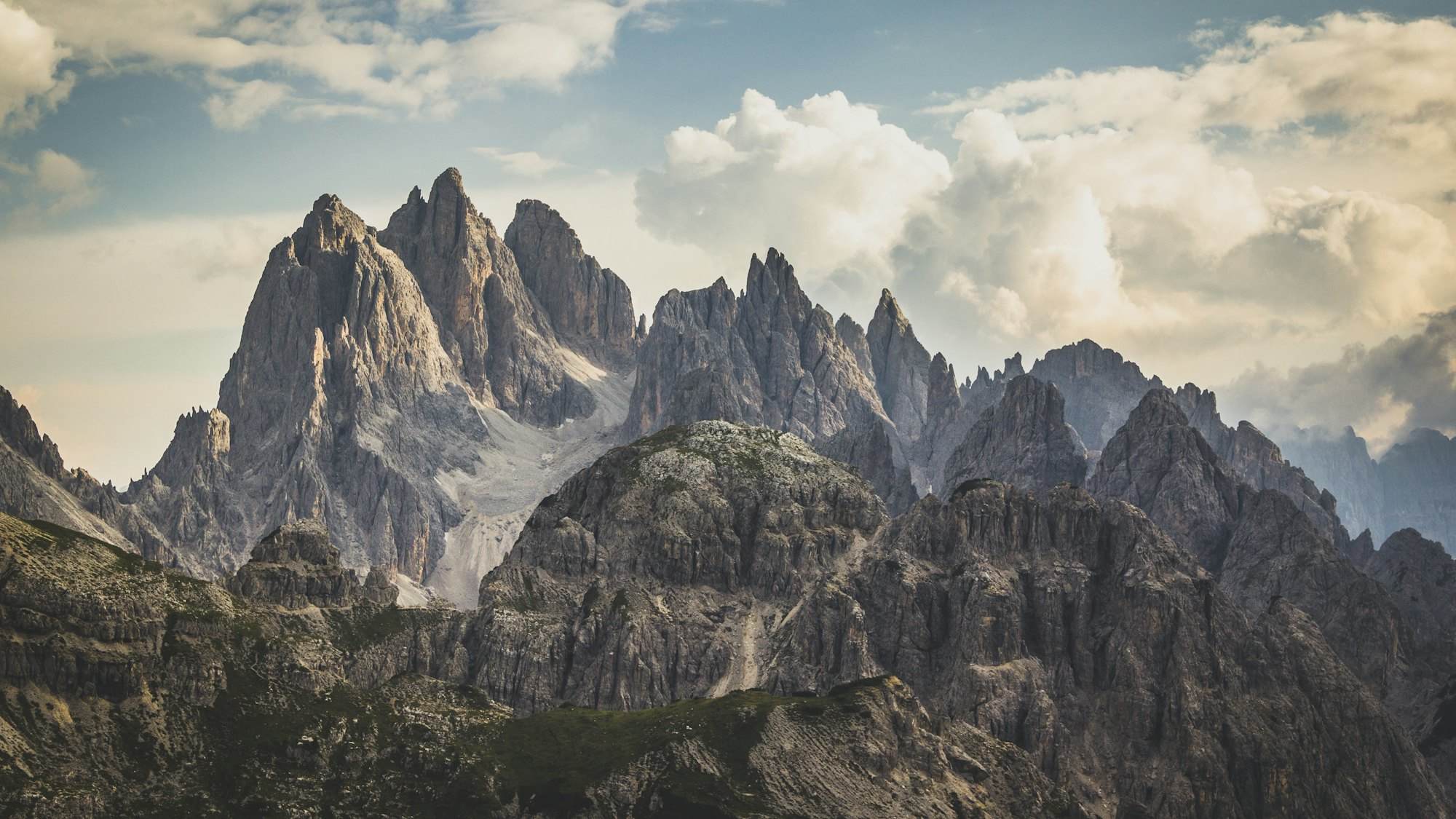 Snow-covered alpine peaks lit by low golden sun against a dark sky