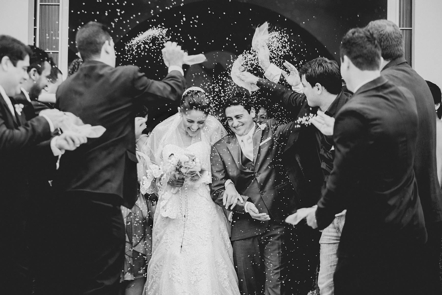 A couple walking together beneath soft window light at a wedding