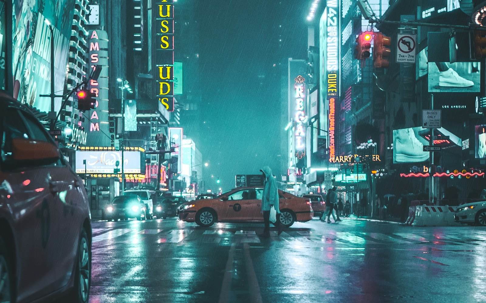 Neon signage reflected in wet asphalt on a city street at night