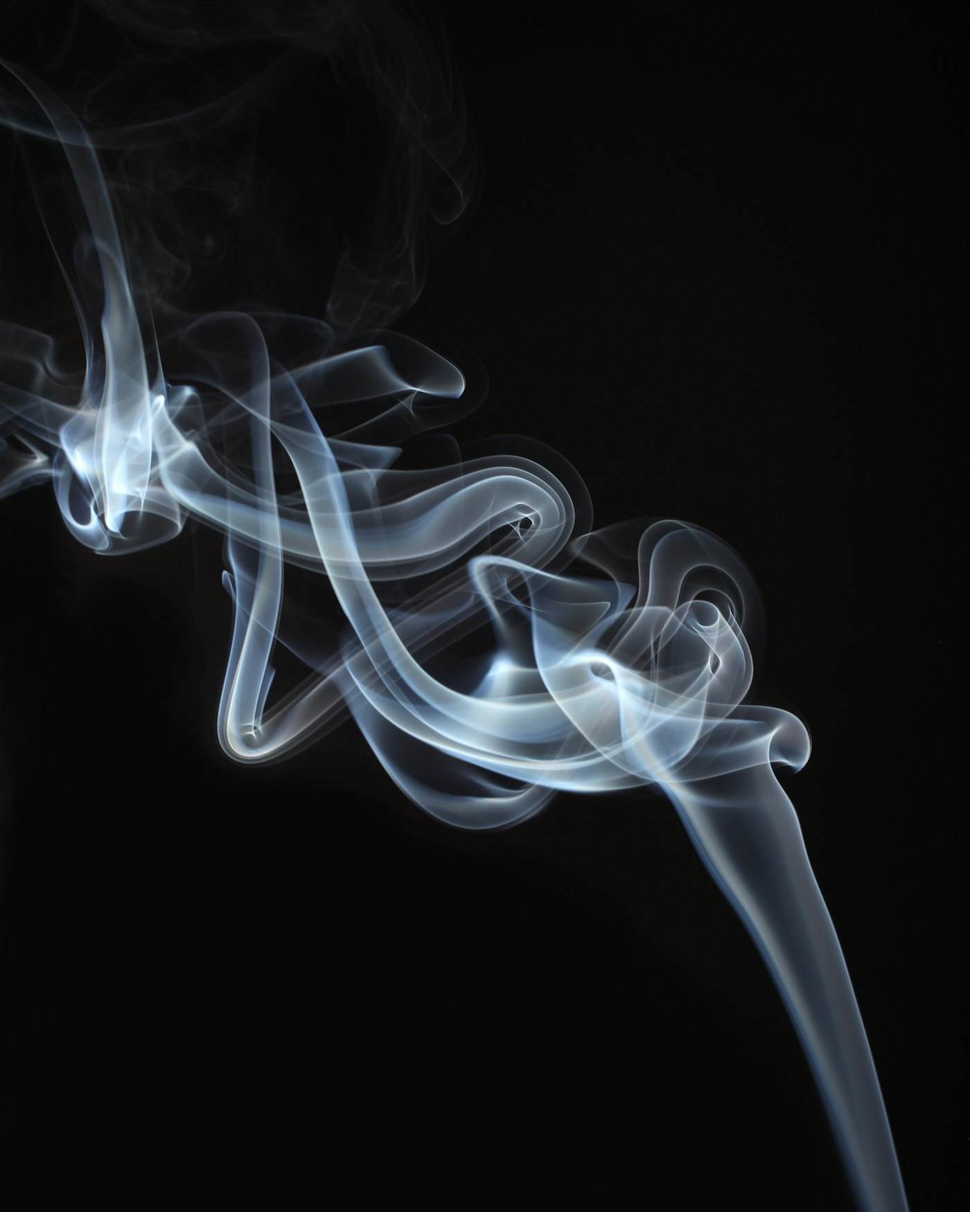 Dense smoke drifting through a shaft of hard light